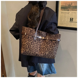 Detail of vintage leopard print tote bag with brown straps and metallic gold buckle accents