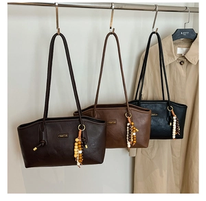 Detailed view of leather tote bags with bohemian beaded tassels and metallic logo