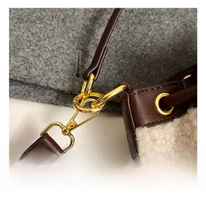 Detail of the high-quality gold metal clasp on the brown leather and beige plush bag