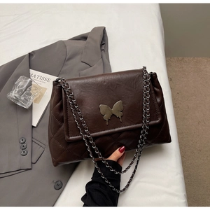 Détail du sac bandoulière matelassé marron foncé avec fermoir papillon en métal et chaîne