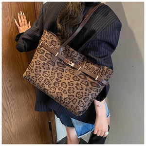 Detail of leopard print tote bag with adjustable shoulder strap and gold metal twist lock