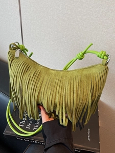 Olive green suede crescent bag featuring long tassels and unique knot shoulder strap
