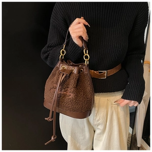 Detail of plush brown drawstring bucket bag with leather trim and gold chain strap