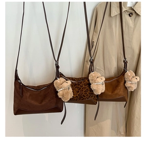 Detailed view of leopard print and suede crescent bags with cute plush dog charms