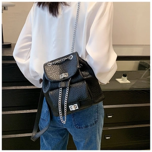 Detail of black leather chain backpack with silver twist lock on model back view