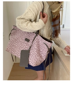 Détail du sac cabas léopard rose avec bandoulière marron et pochette assortie