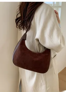 Detailed texture of dark brown suede hobo bag worn by a model in soft natural light