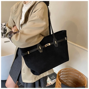 Chic black suede tote bag with gold buckle detail shown on shoulder with a khaki coat