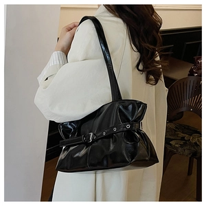 Detail of vintage black patent leather shoulder bag with adjustable strap and silver buckle
