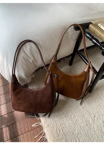 Detail of retro suede hobo bags in dark coffee and caramel with leather trim and drawstrings