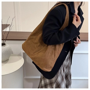 Brown corduroy tote bag shown on model highlighting large capacity and soft texture