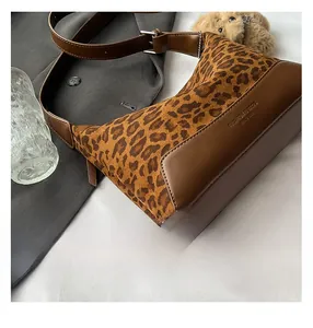 Detail of leopard print suede and brown leather texture on a trendy shoulder bag