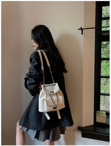Close-up of white lychee texture leather mini backpack with silver chain and twist lock