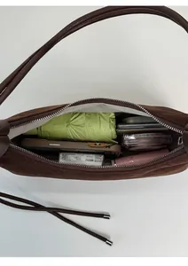 Interior view of brown suede dumpling bag showing large capacity for daily essentials