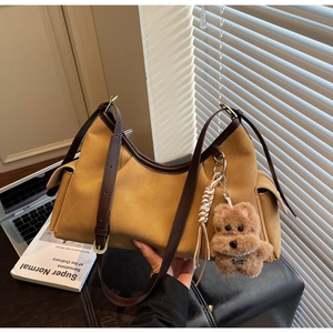 Dettaglio borsa a tracolla vintage giallo zenzero con ciondolo a forma di cucciolo