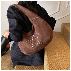Detailed macro view of the silver star rivet design on a brown suede underarm bag