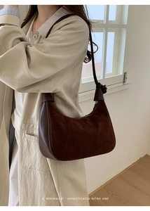Dark brown suede crescent bag shown as a shoulder carry style on a model