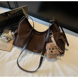 Dettaglio borsa hobo marrone scuro con texture scamosciata e ciondolo a forma di cane