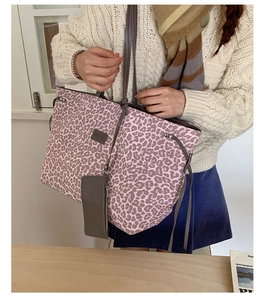 Détail du cabas léopard avec sa petite pochette assortie et ses anses en cuir foncé