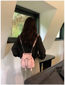 Close-up of a pink pebbled leather mini backpack featuring chain straps and front pockets
