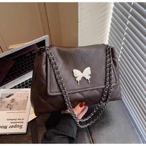 Détail du sac cabas matelassé marron foncé avec fermoir papillon argenté et chaîne