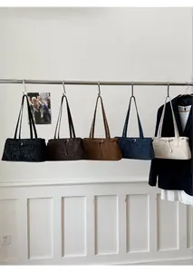 Detailansicht von fünf minimalistischen Tragetaschen in verschiedenen Farben an einer Stange