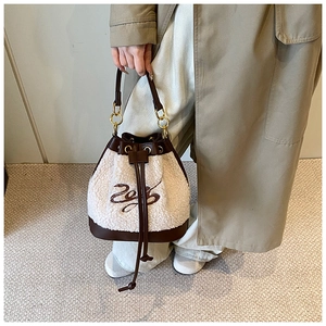 Detail of plush bucket bag with lamb wool texture and faux leather drawstring accents