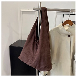 Detailed view of the dark coffee matte leather texture and drape of the tote bag