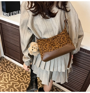 Leopard print canvas crossbody bag featuring a cute plush dog charm and leather trim