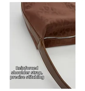 Detail of reinforced shoulder strap and precision stitching on brown leopard bag