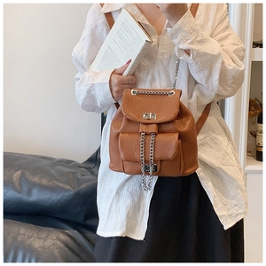 Detail of vintage brown bucket backpack showing litchi texture and silver metal turn lock