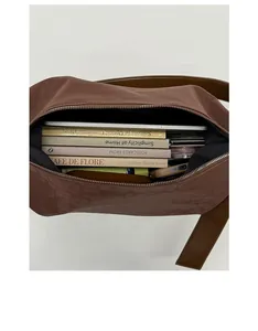 Macro view showing spacious interior of brown faux leather shoulder bag for books and phone