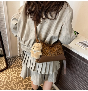 Leopard print crossbody bag with brown faux leather trim and plush puppy charm detail