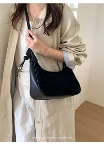 Side view of a black leather hobo bag with unique knot detail and metal hardware