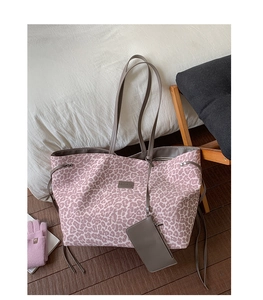 Détail du sac cabas léopard rose avec poignées en cuir gris et petite pochette