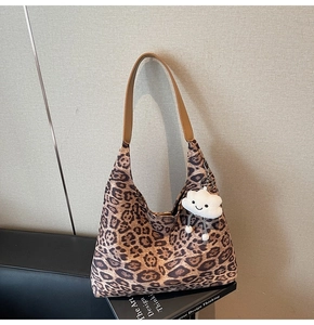 Detailed macro of leopard print hobo bag texture with a cute plush cloud charm