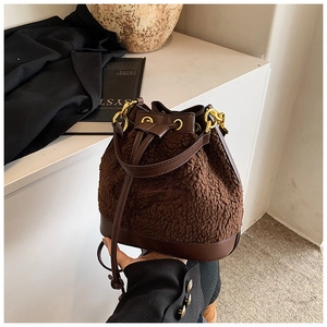 Detail of plush brown bucket bag showing lamb wool texture and sleek leather trim