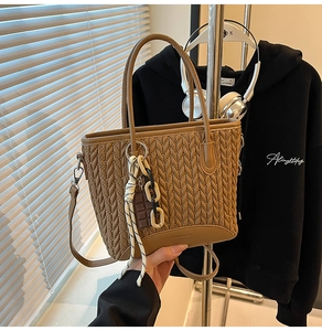 Detailed shot of brown quilted bucket bag with woven texture and trendy bag charm