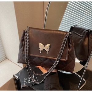 Détail du sac cabas matelassé marron foncé avec boucle papillon et bandoulière chaîne