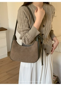 Detail of retro hobo bag in dark brown suede and olive green leather stitching