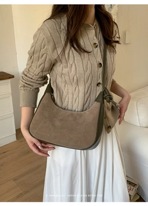 Detail of retro suede and green leather patchwork bag with minimalist knotted handle