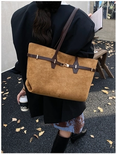 Close-up of leopard print tote bag with brown straps and golden buckle detail