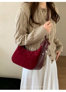 Close-up of retro burgundy hobo bag featuring matte suede texture and knot detail