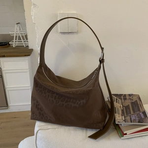 Detail of leopard print hobo bag showing adjustable strap and silver metal zipper closure