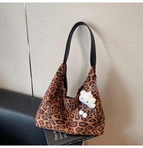 Detail of leopard print suede hobo bag with black leather strap and cloud charm