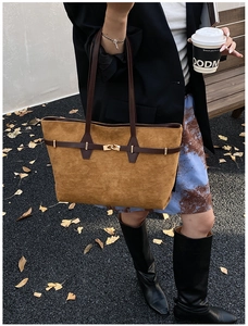 Detail of a brown leopard-style suede tote bag with a golden twist lock and leather strap