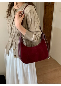 Close-up of retro wine red crescent shoulder bag with suede and leather contrast