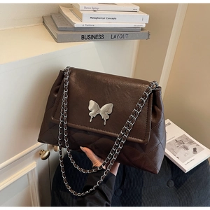 Détail du sac matelassé marron café avec boucle papillon argentée et bandoulière