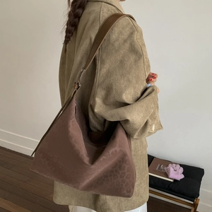 Detail of large brown leopard print hobo bag in suede texture with wide shoulder strap