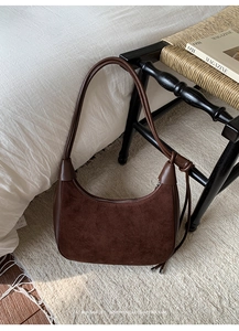 Detail of vintage brown suede hobo bag with smooth leather trim and premium stitching